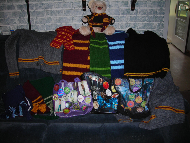 A picture of some of the harry Potter stuff that i have knit and croched. It includes 2 gryffindor house sweaters, 1 gryffindor scarf, one gryffindor sweater vest, one gryffindor knitted purse, 1 slytherin scarf and one slytherin knitted purse, one ravenclawscarf and one ravenclaw knitted purse, three purses that i made using iron on transfers, and a teddy bear wearing a gryffindor scarf and sweater, both of which i croched.